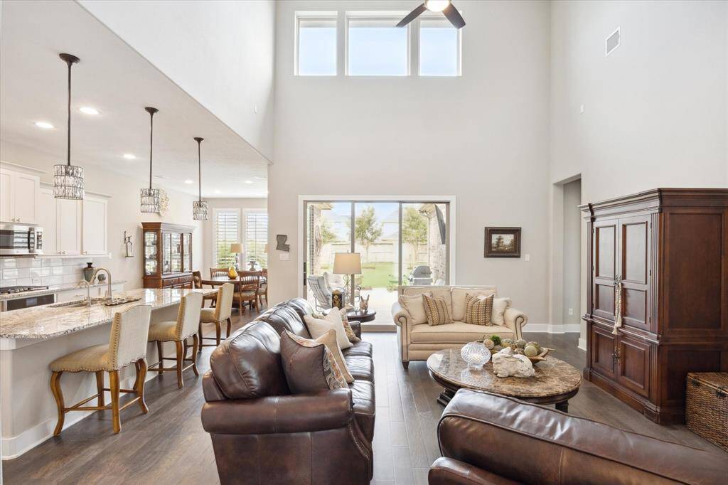 Experience the elegance of soaring ceilings and seamless indoor-outdoor living with triple doors opening to the patio and yard.