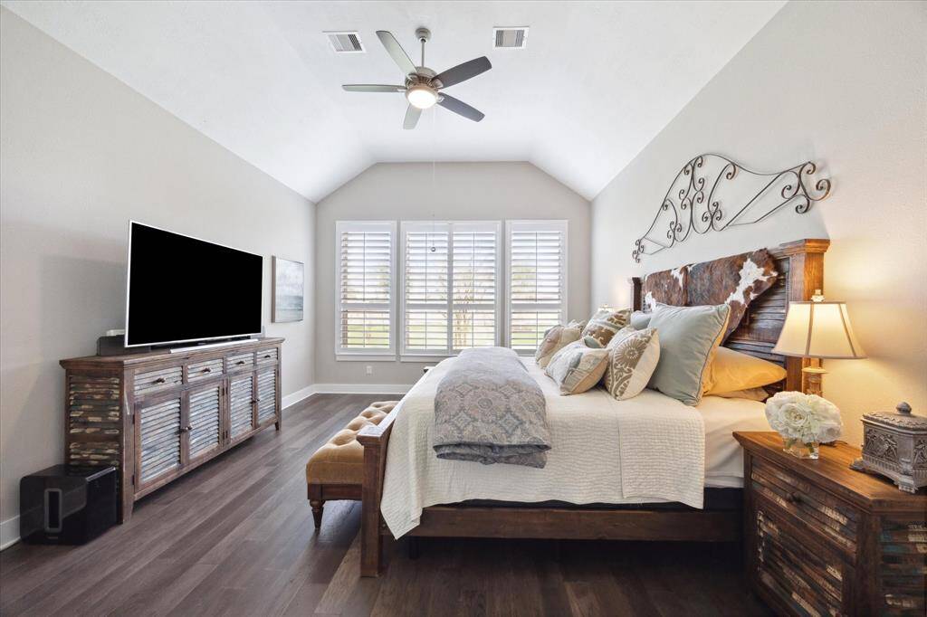 Spacious primary suite featuring elegant decor, abundant natural light, and a cozy ambiance for ultimate relaxation.