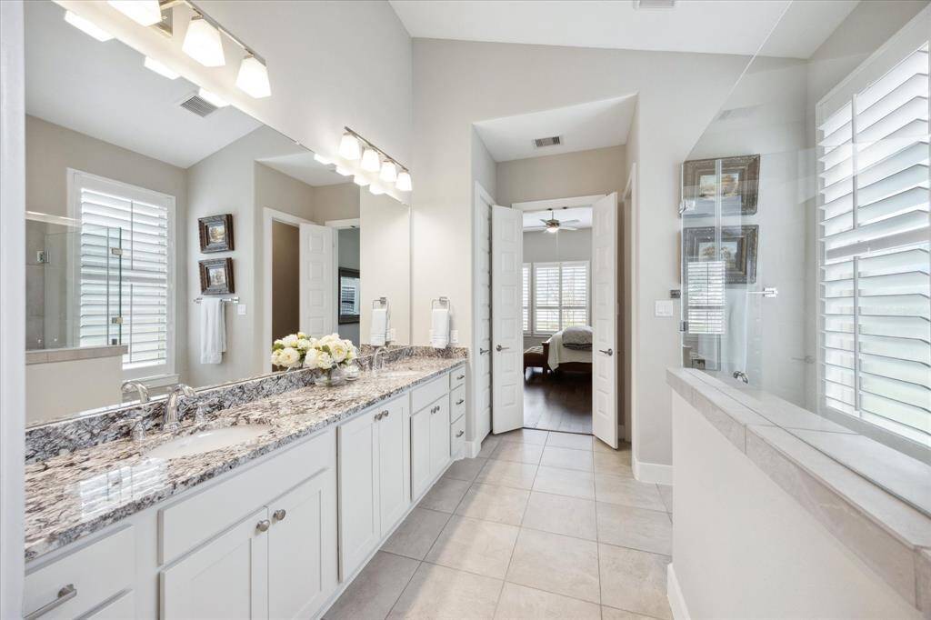 Experience luxury in the primary bath with its spacious, seamless glass-enclosed shower.