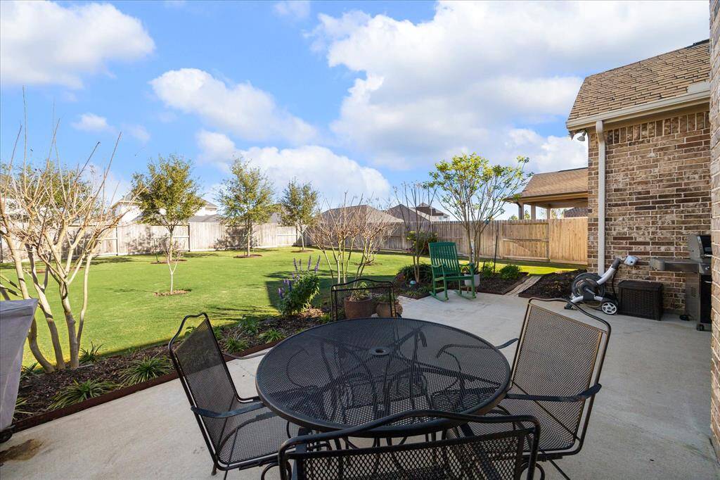 Experience serene outdoor living with a spacious patio overlooking a lush backyard. Beautiful Oak trees line the back perimeter.