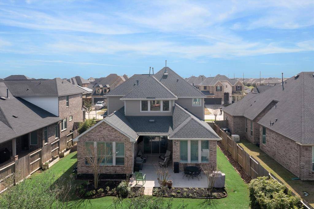 Backyard view with lush landscaping and inviting patio space.
