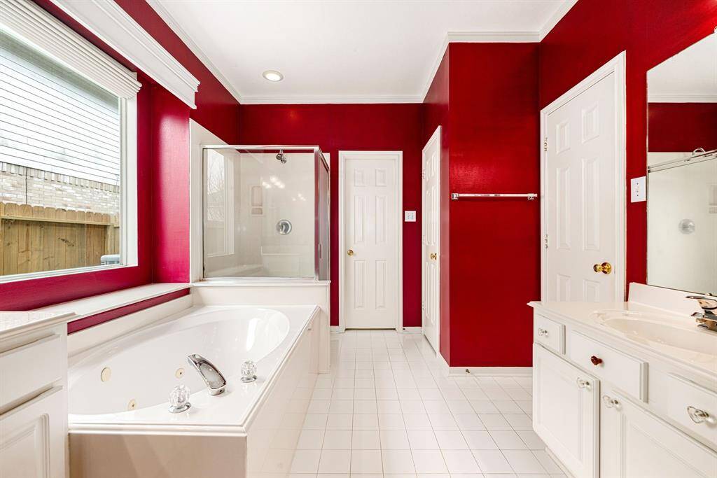 This additional view of the primary bath showcases a walk-in shower with tile surround and a separate garden tub perfect for soaking after a long day.