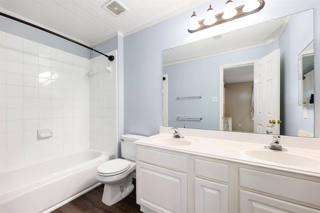Secondary bathroom features light countertops and cabinets, custom paint, shower/tub combo with tile surround, large mirror, tile floors, sleek fixtures and modern finishes, plenty of space to accommodate any visiting family or guests.