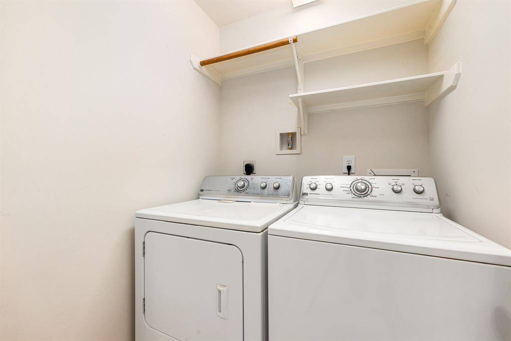 A convenient laundry nook featuring built-in shelving.