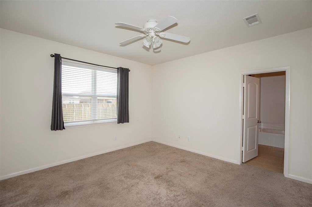 Large primary bedroom with a window that overlooks the backyard.
