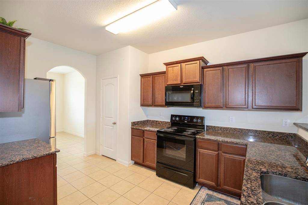 The kitchen features granite counters and beautiful wood cabinetry.