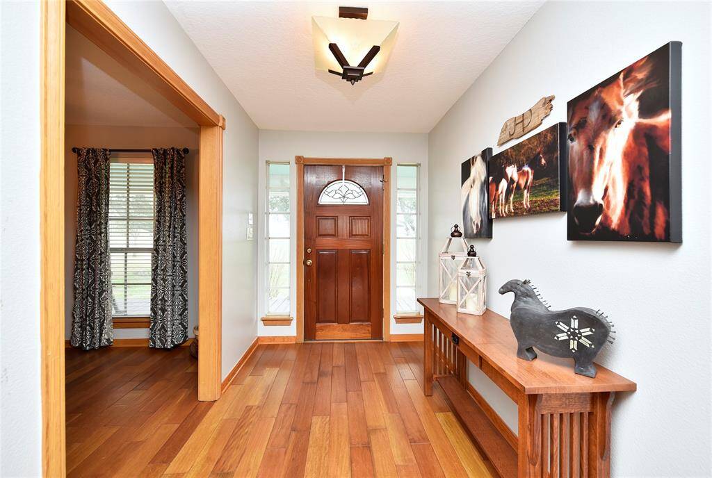 Welcome to a charming foyer featuring elegant hardwood floors, natural light, and tasteful decor—your perfect introduction to this inviting home.