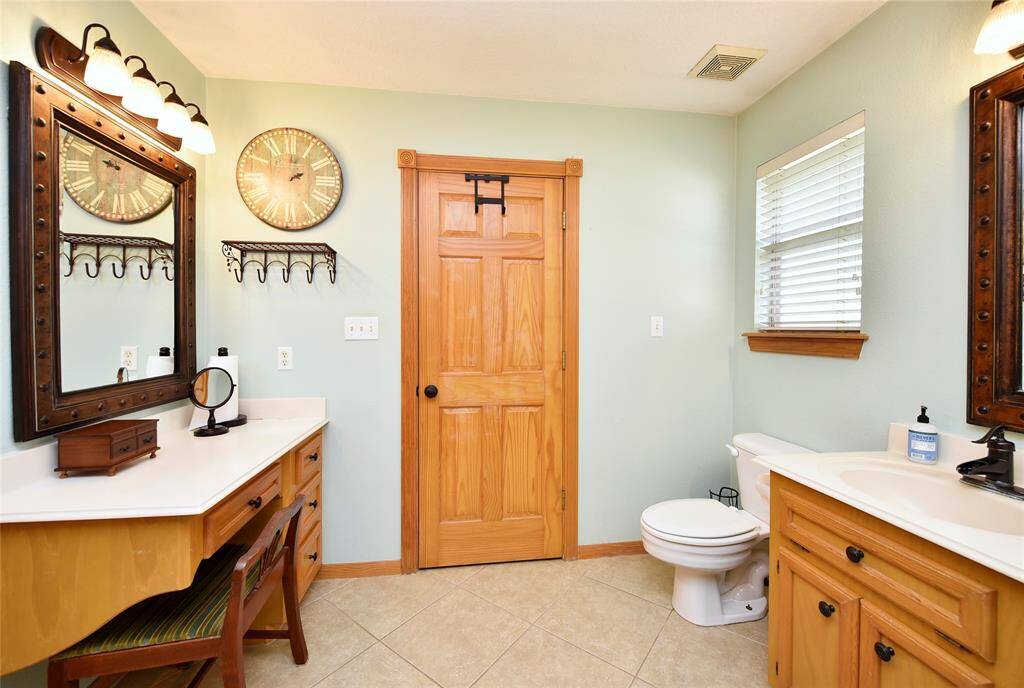 Luxurious primary bathroom featuring a stylish dressing vanity for your convenience.
