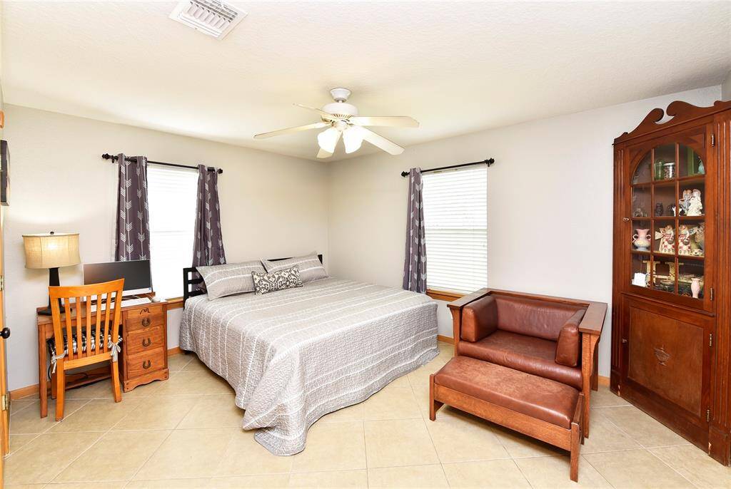 Cozy third bedroom featuring ample natural light, a comfortable layout, and space for a work area—ideal for relaxation or productivity.