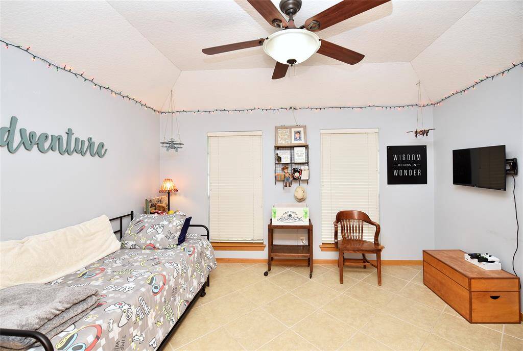 Cozy bedroom featuring high ceilings, soft lighting, and ample natural light—ideal for relaxation or creativity.