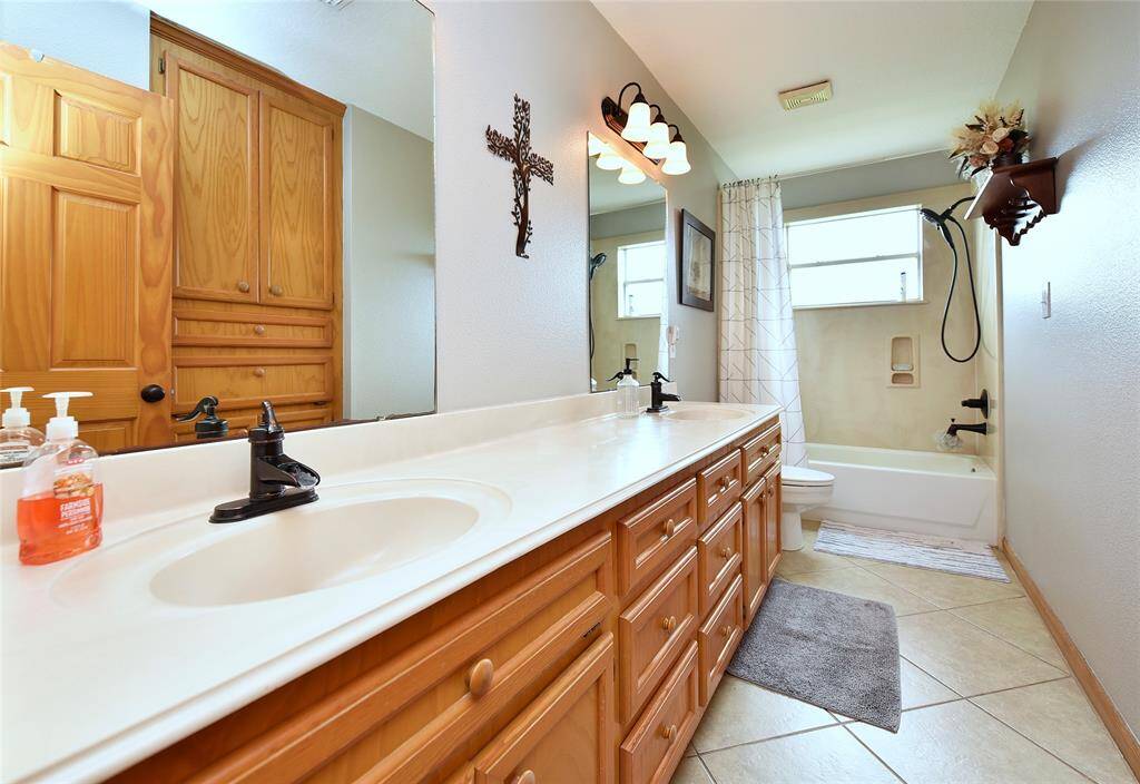 Spacious hall bath featuring elegant double sinks for added convenience.