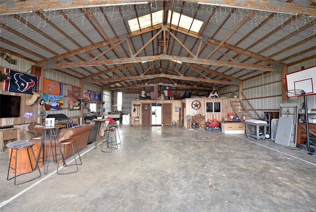 Spacious barn with high ceilings, a cozy lounge area, and versatile space for recreation or storage. Perfect for entertaining or creative projects.