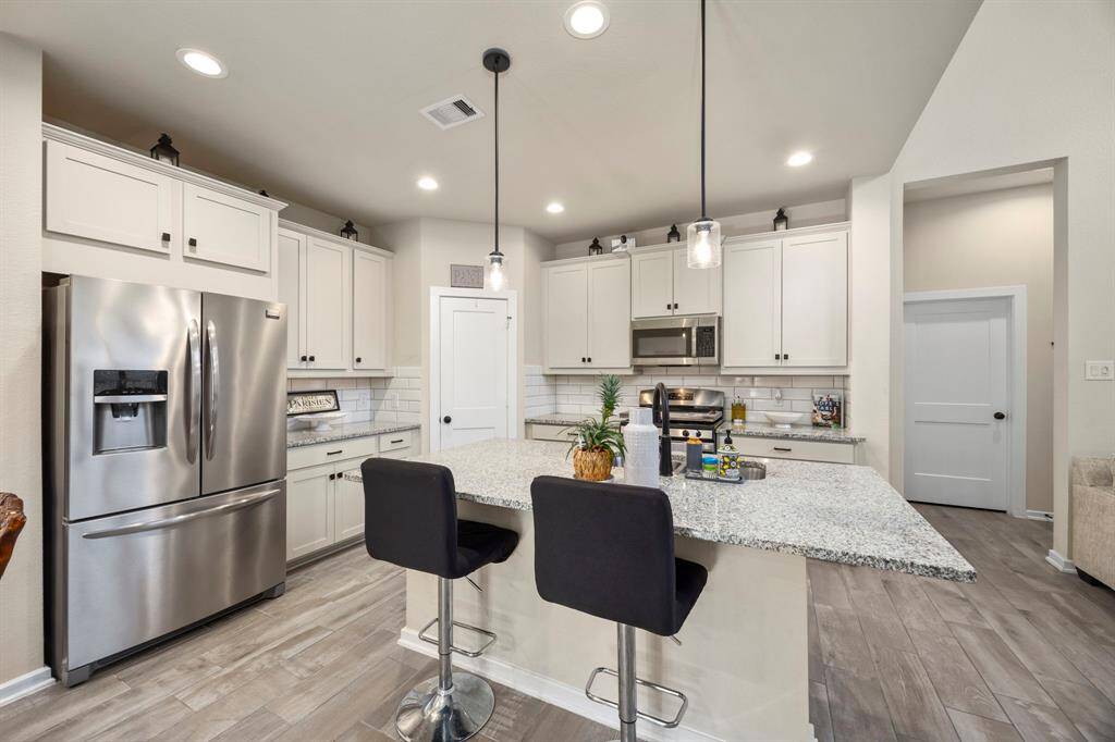 Quality cabinets, modern lighting, and large overhang countertops for bar seating around the front and side of the island.