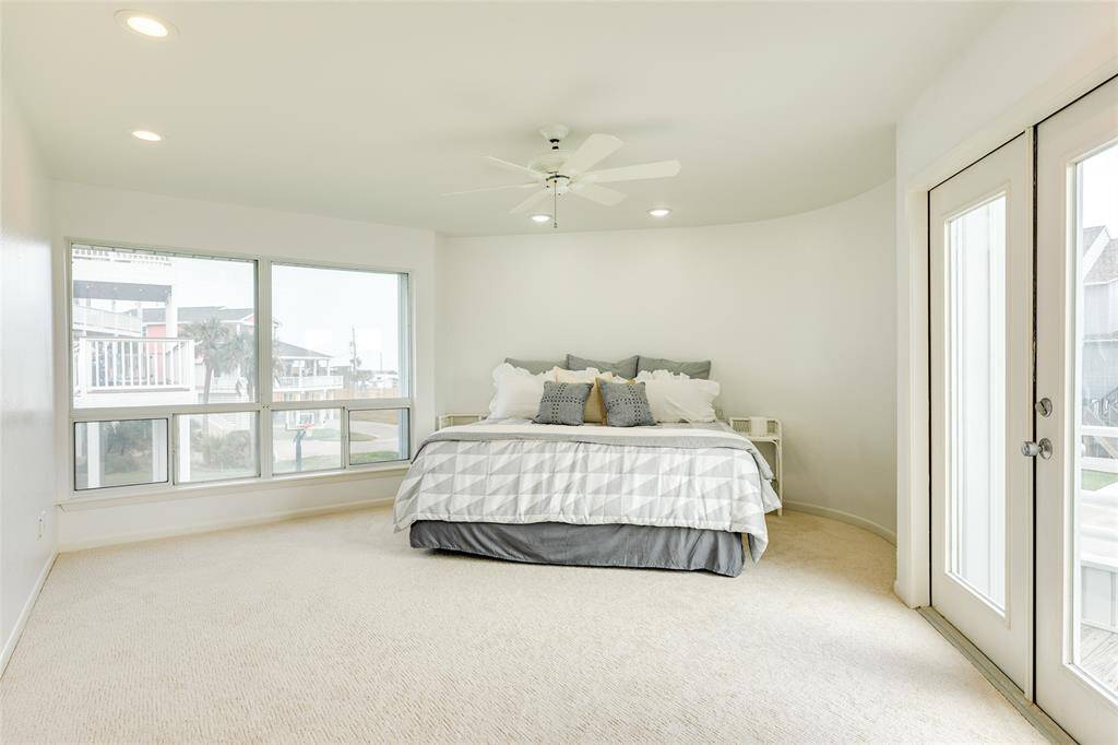 Just off the large living area is the spacious main-level Primary Suite. This room features great natural light, space for a sitting area, and French doors to the HUGE deck with excellent Gulf views.