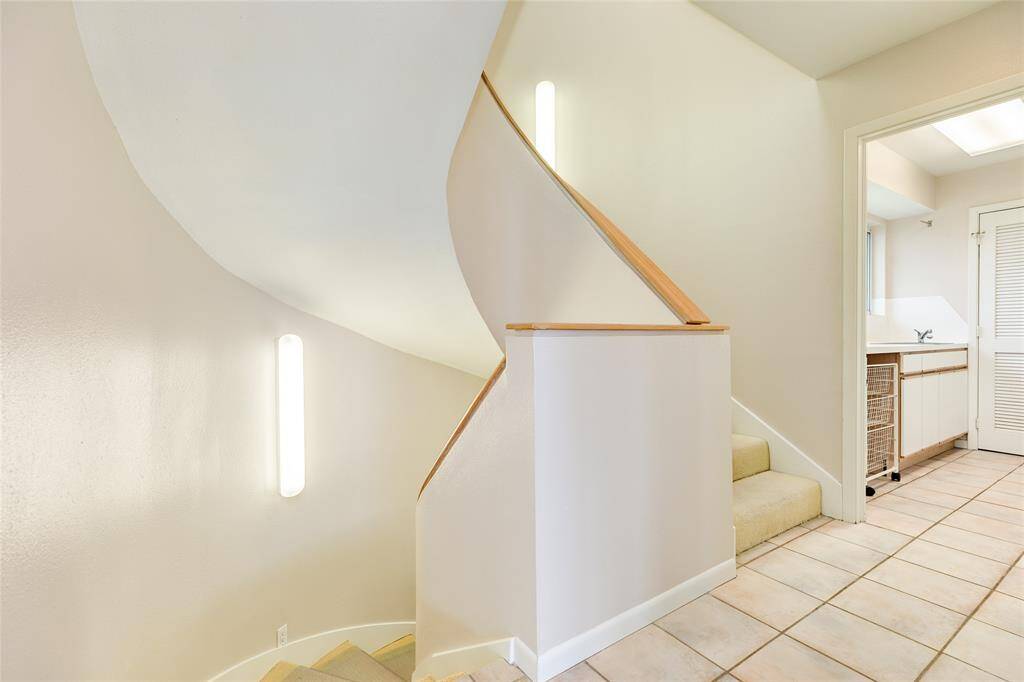 Back to this artistic and gracefully designed staircase, we notice the large utility room on the right before we head up the stairs.