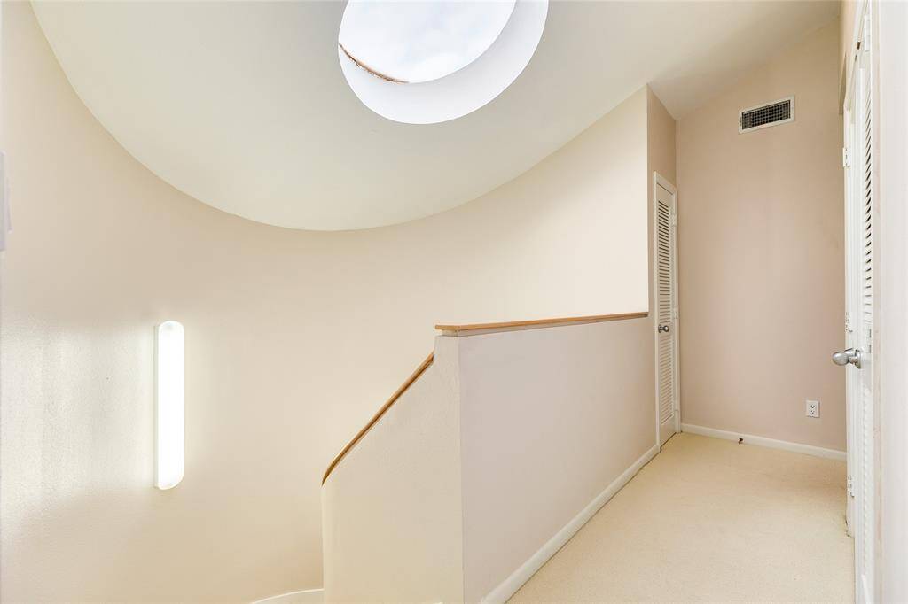 At the top of the stairs, note the skylight offering natural light into this beautiful design.