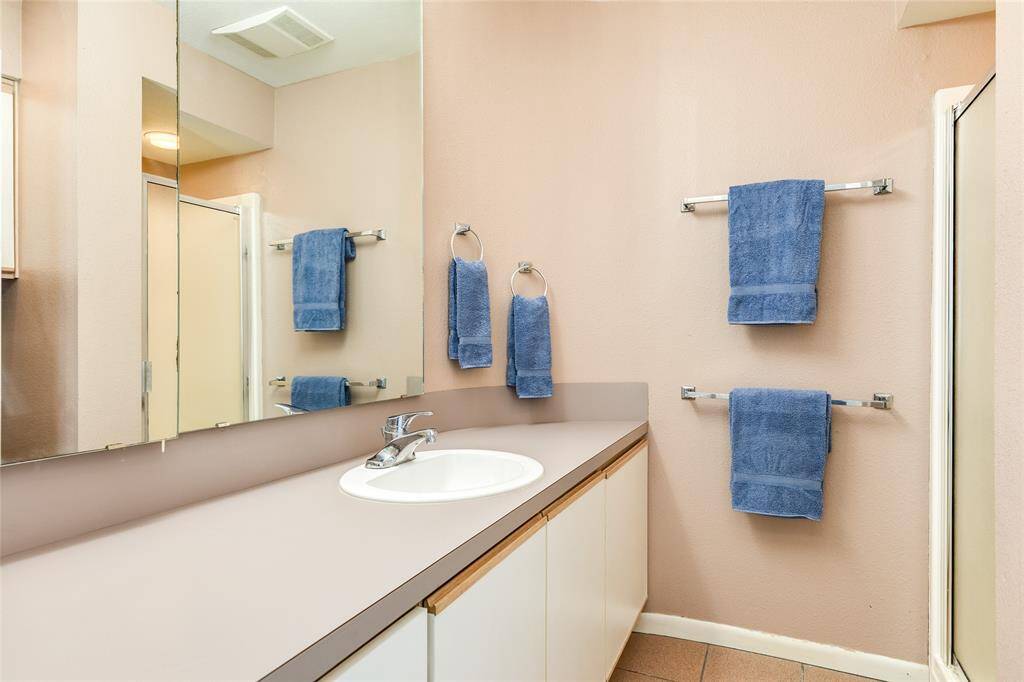 The second-level Primary en-suite offers a walk-in shower and loads of storage and counter space.