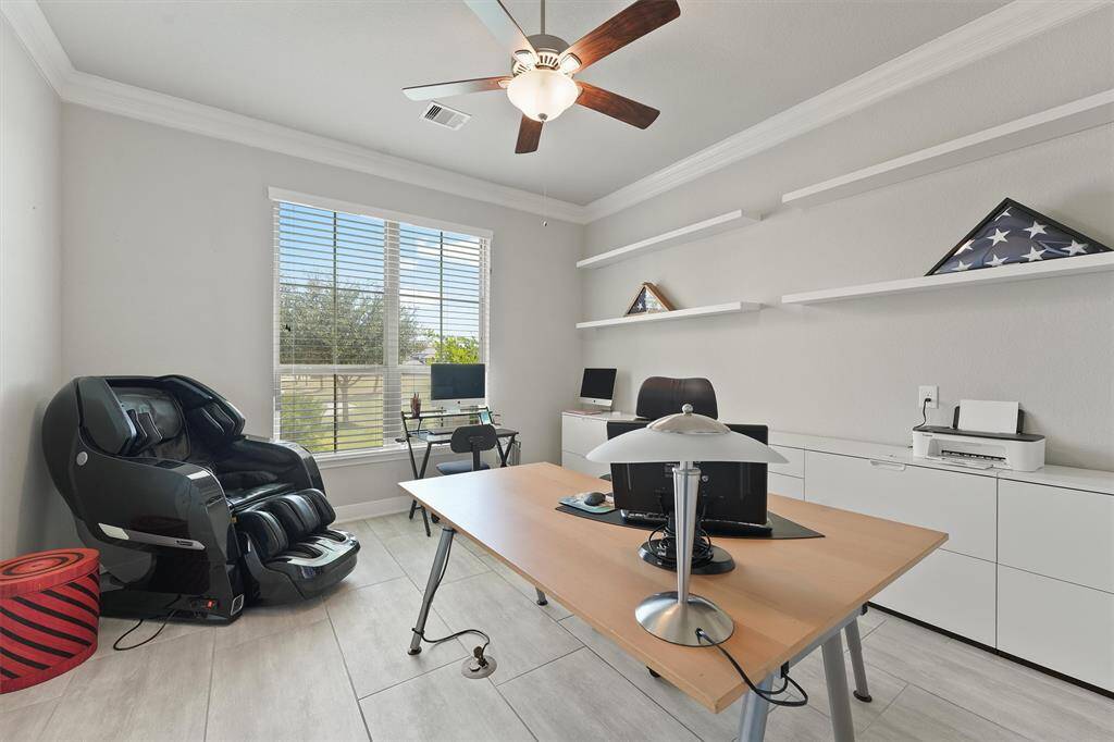 This room is a bright, modern home office space with nice natural lighting overlooking the front yard.
