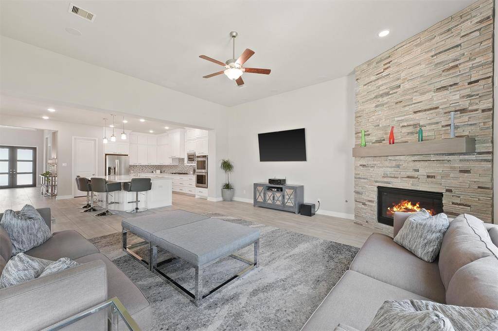 This photo showcases a spacious, open-concept living area with a cozy fireplace. The room is well-lit and inviting, ideal for entertaining or relaxing.