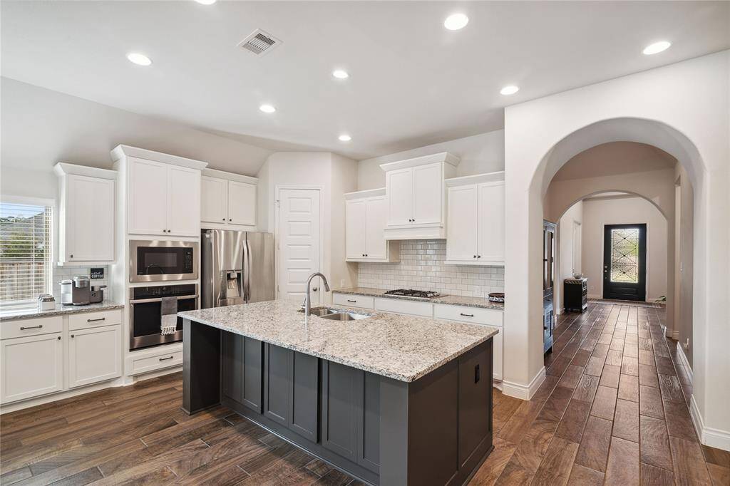As you move through and pass the home office and Bedroom #4, you enter this very open and inviting kitchen!