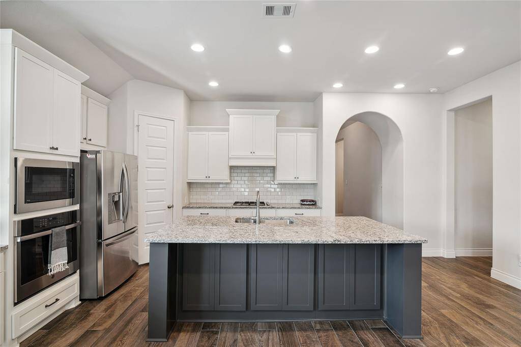 Wow, what a kitchen! Generous granite counter island with built-in breakfast bar and usable cabinets below!