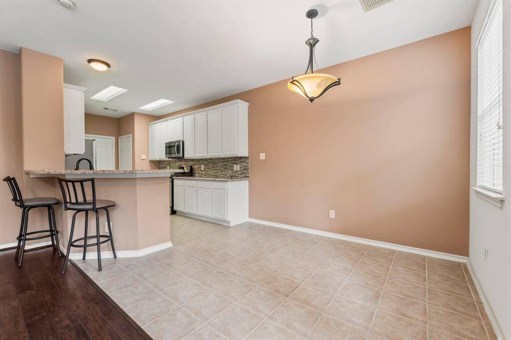 Additional Dining/Breakfast area is great for family dinners or a morning cup of coffee!  Features include tile flooring, decorative chandelier, and sunny window with blinds.