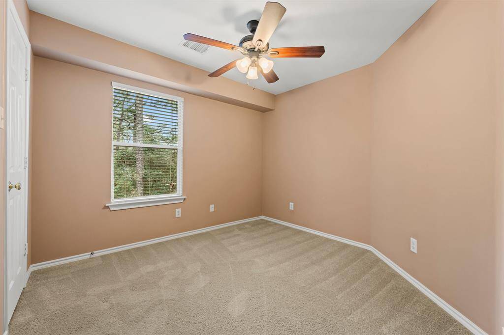 Another  secondary bedroom offers lush carpeting, large walk-in closet with built-in shelving, sunny window with privacy blinds and greenbelt views, and a lighted ceiling fan. It has hallway access to a full bath shared with Bedroom 3.