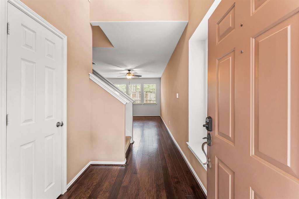 The two-story Foyer is welcoming, with a bench seat situated under a wall of windows. The warm wood flooring, crown molding, and decorative chandelier add the finishing touch!