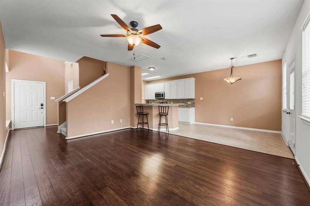 Great view of this home’s elegance looking toward the kitchen.  Warm wood flooring flows from the Foyer through to the living area. You will love this open concept floorplan that makes family living easy and is a dream for entertaining.
