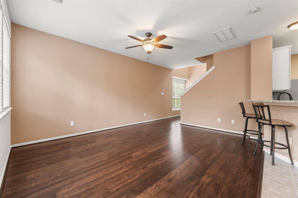 Family room features include wood flooring, three windows with blinds, and lighted ceiling fan. Located directly off the kitchen, it is easy to enjoy conversation with everyone in the area. There's plenty of wall space for all your furniture in this spacious living area.