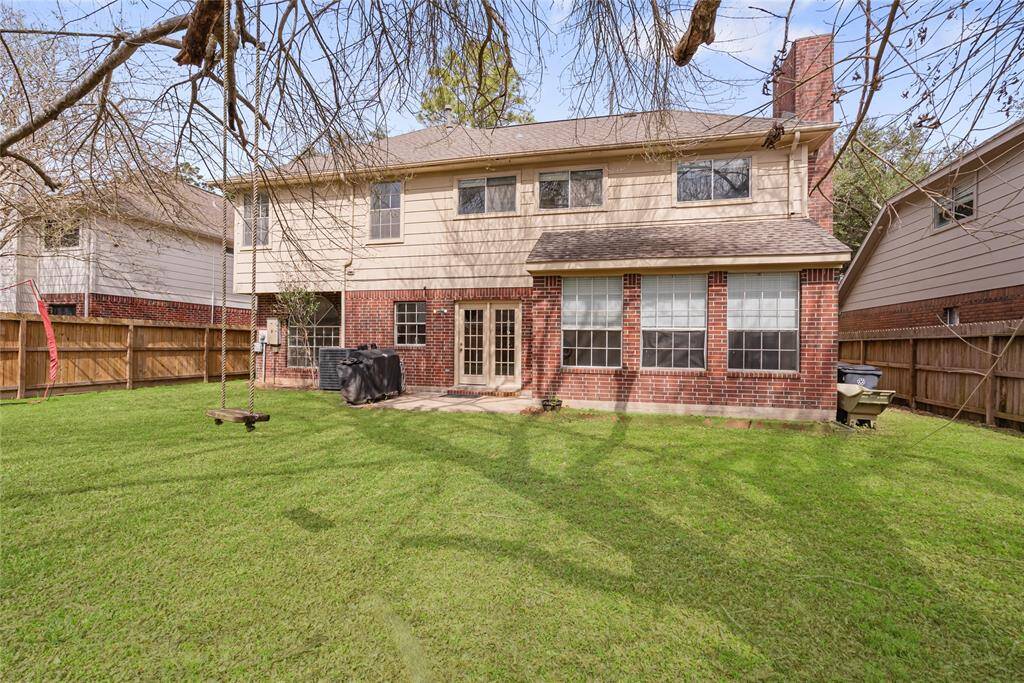 The photo showcases a spacious backyard with a well-maintained lawn, a large tree, and a wooden privacy fence. It's an inviting space for outdoor activities and relaxation.