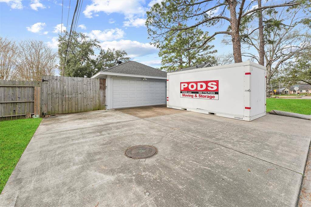Extra large wide drive way with an additional space for parking behind the fence.