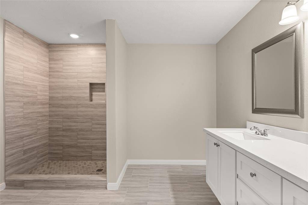 This primary bathroom is definitely move-in ready! Featuring a large walk-in shower with tile surround, white stained cabinets with light countertops, spacious walk-in closet with shelving, high ceilings, custom paint, sleek and modern finishes.