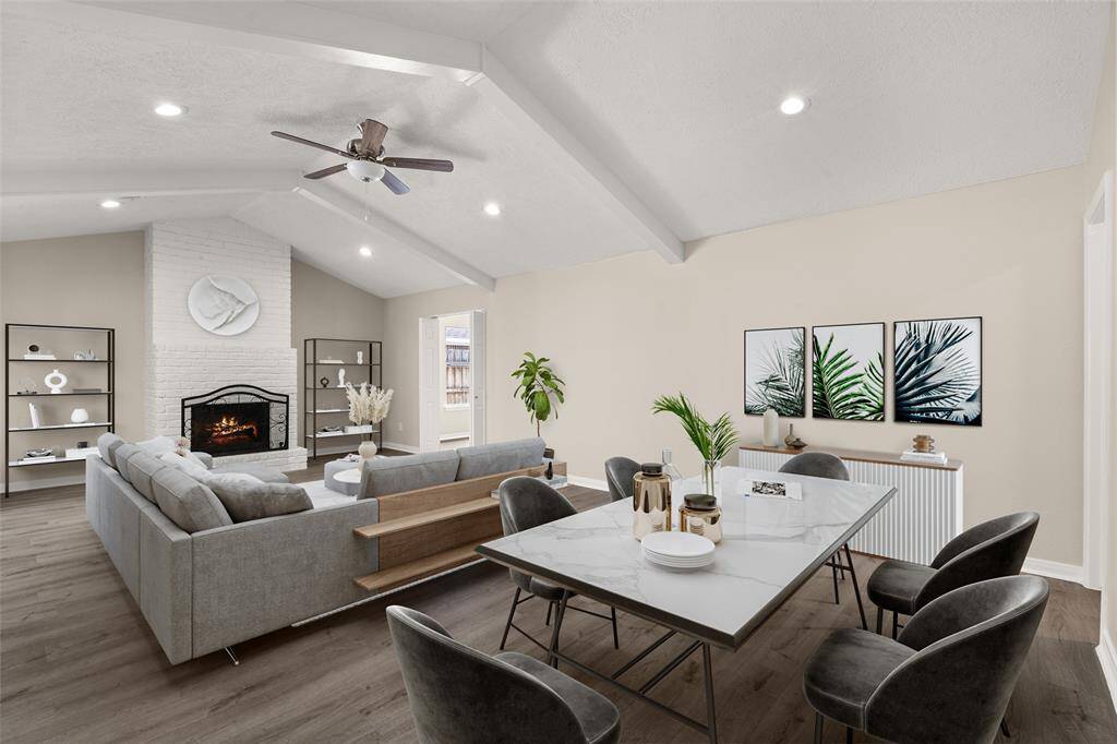 Gather the family and guests together in your lovely living room! Featuring soaring high ceilings, recessed lighting, dark stained ceiling fan, custom paint, gorgeous flooring, and fireplace.