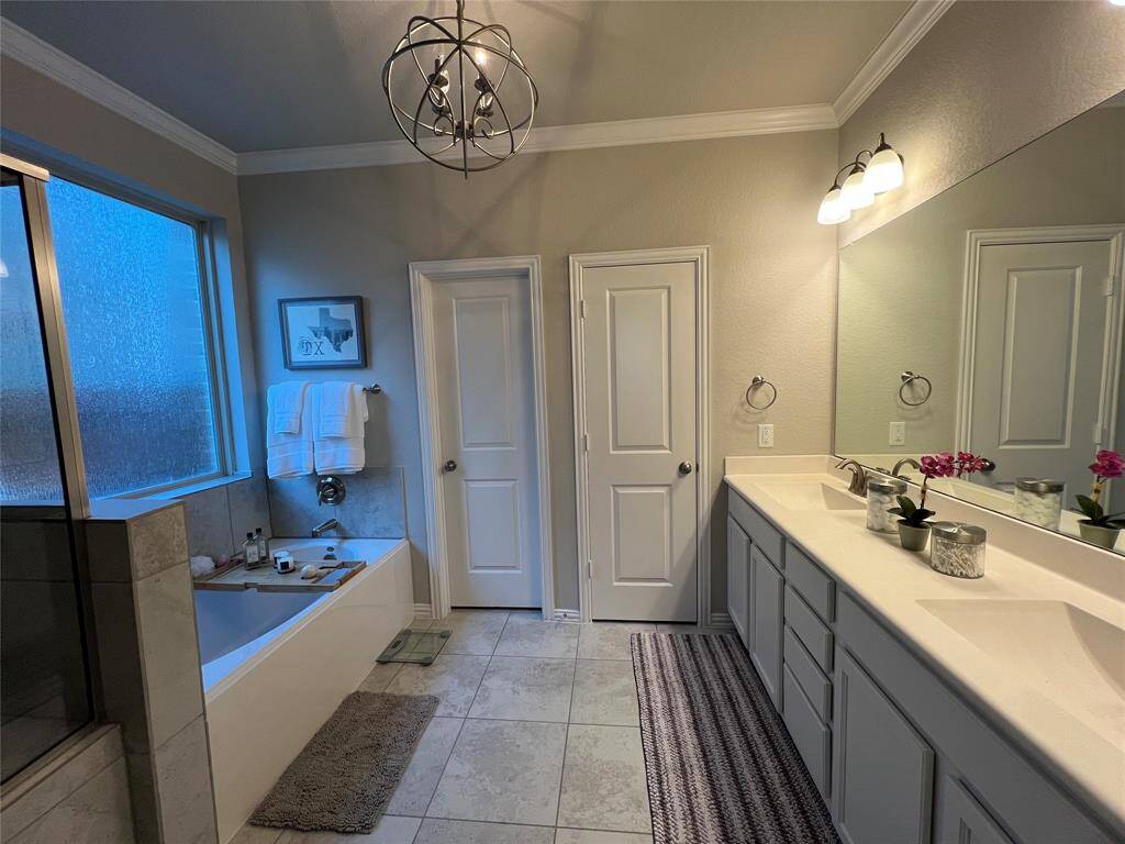 Another view of primary bath including dual walk in closets.