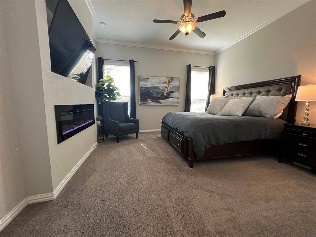 Luxurious primary retreat features large windows overlooking pool, ensuite bathroom with dual vanities and custom fireplace and sitting area.