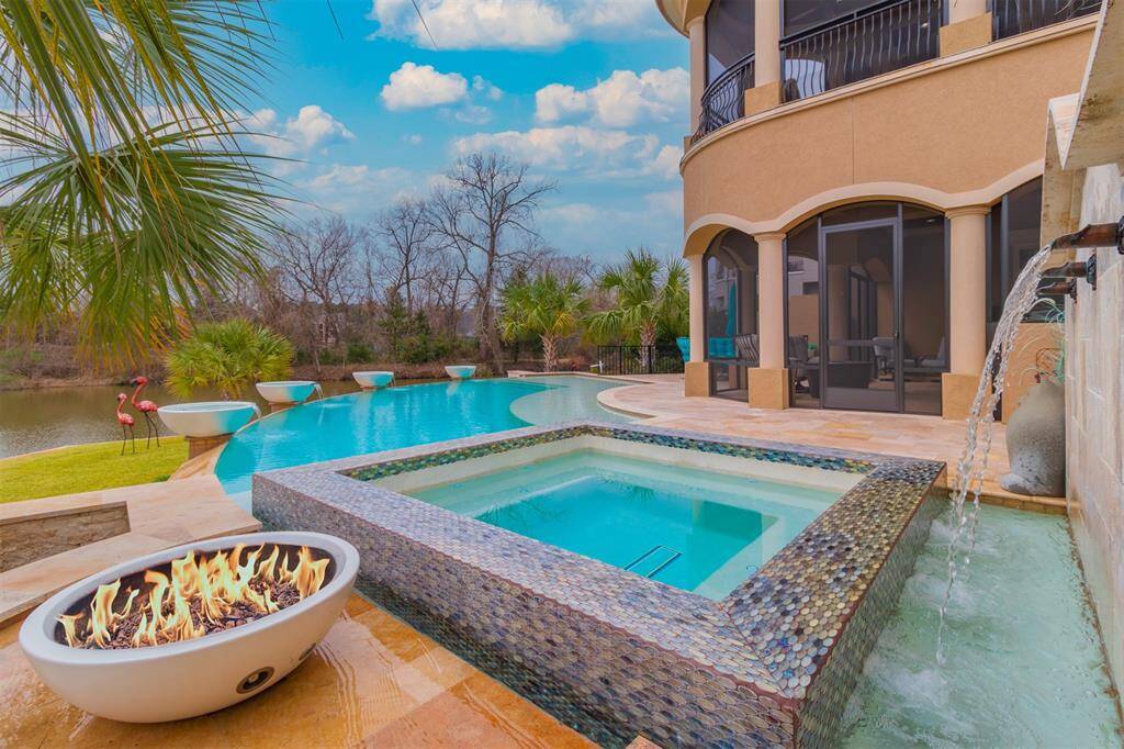 Tiled spa with cascading privacy wall and fire bowl.