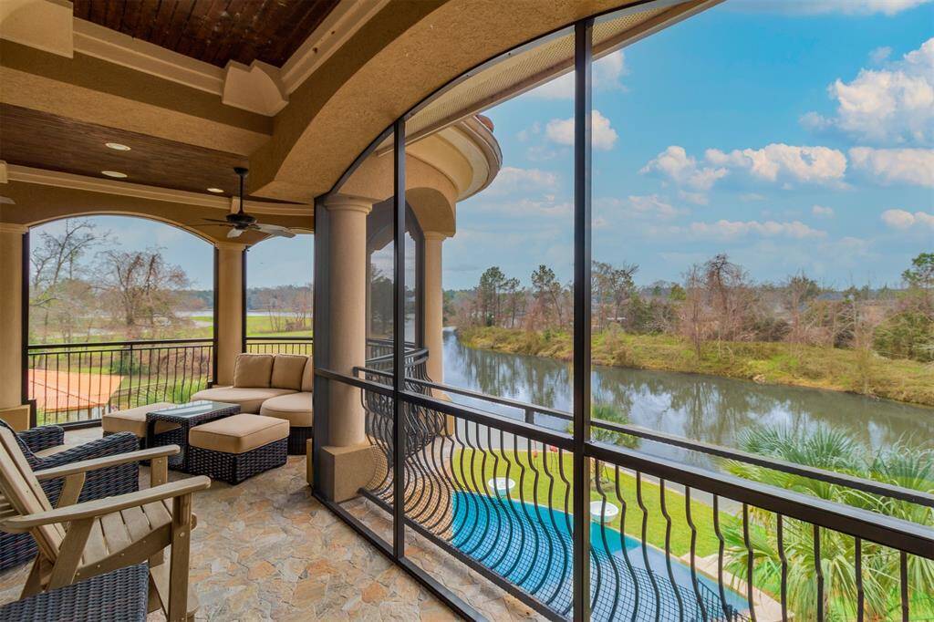 Upper balcony screened in with views of the fabulous pool and lake.
