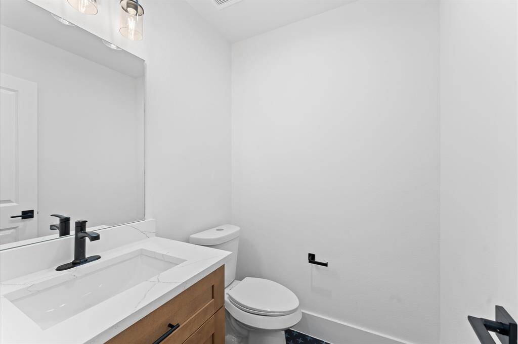 This bright room features large windows for natural light, recessed lighting, white walls, and wood-style flooring, creating a modern and spacious feel.