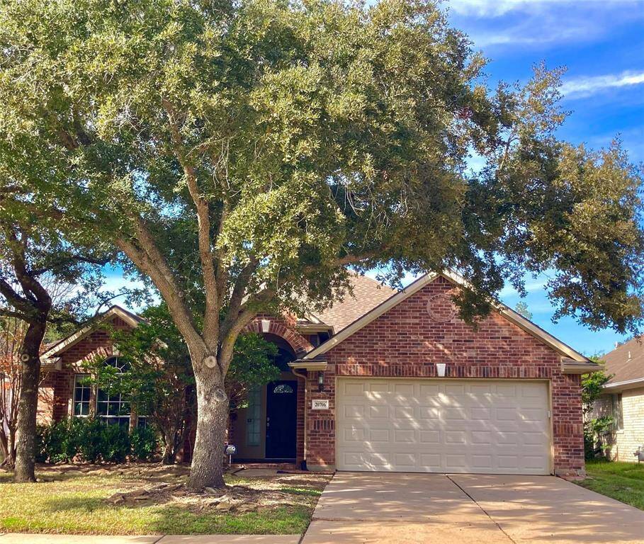 This charming brick home features a two-car garage and a welcoming front entrance. A large, mature tree provides shade to the front yard, enhancing the curb appeal. Ideal for family living in a serene neighborhood.