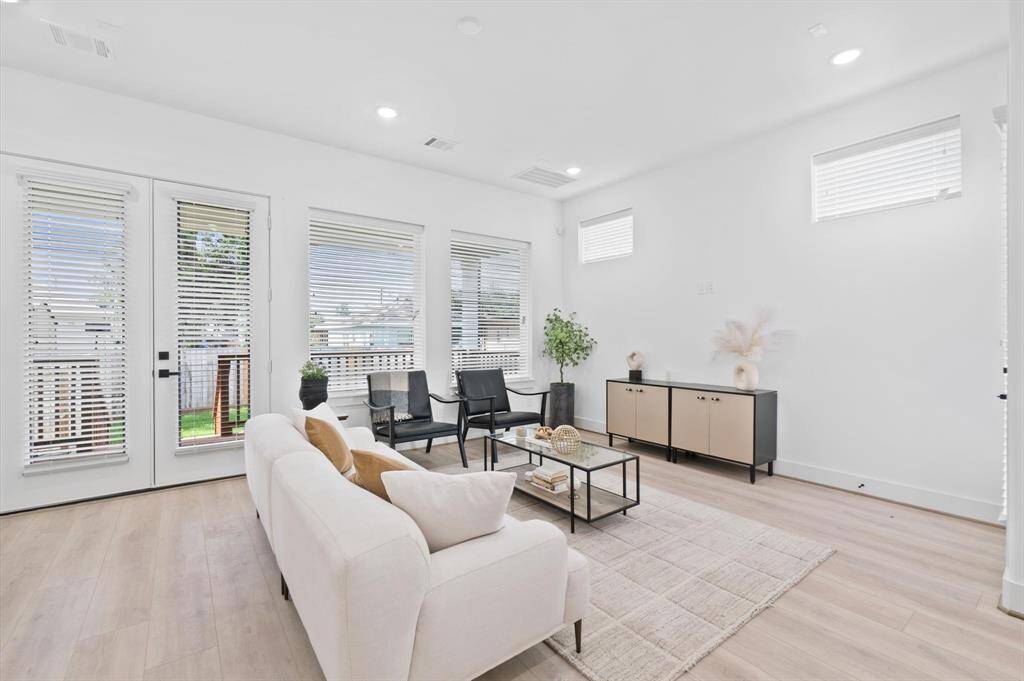 Elegant French doors and windows overflow the area with natural light yet controlled by blinds. The double doors open to a spacious, covered patio, perfect for outdoor living.