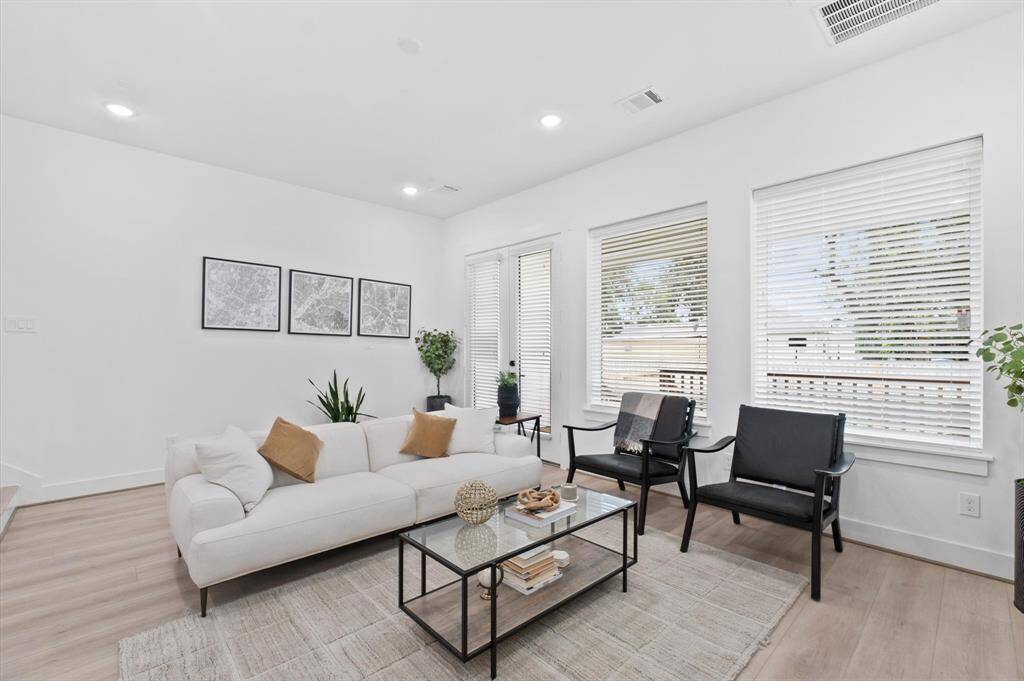 Elegant French doors and windows overflow the area with natural light yet controlled by blinds. The double doors open to a spacious, covered patio, perfect for outdoor living.