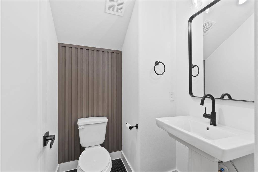 Stylish first-floor half bath featuring a modern accent wall.
