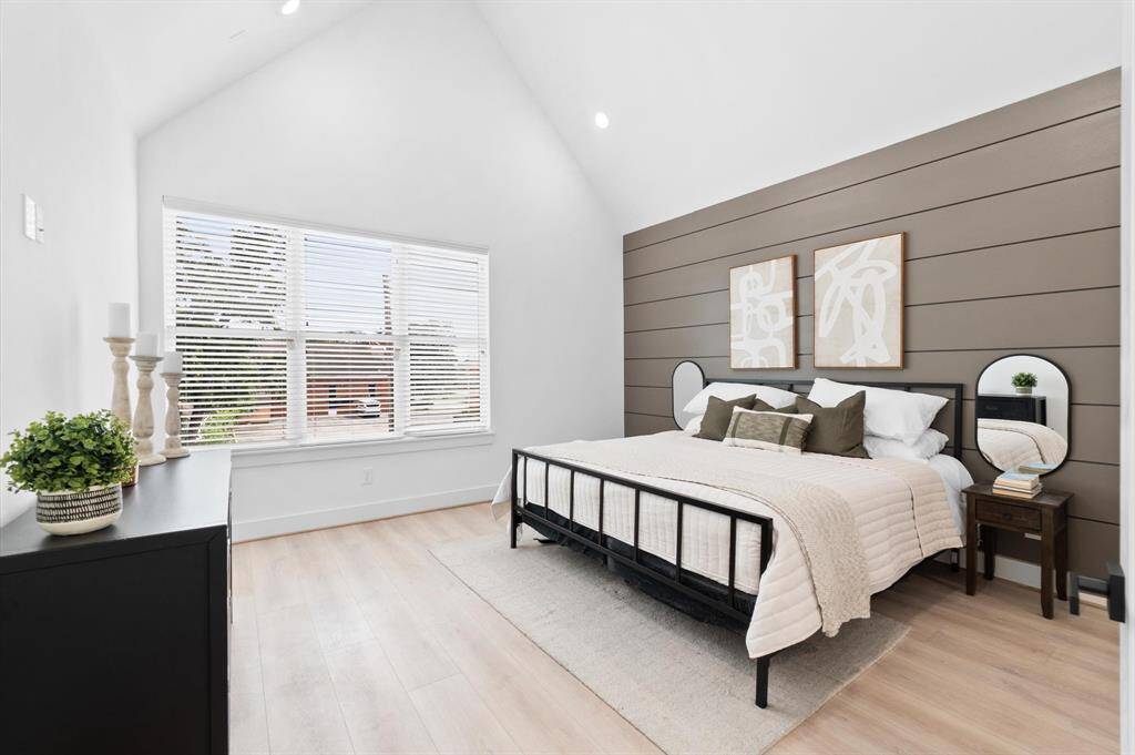 Experience the elegance of the primary suite, featuring a soaring cathedral ceiling, stylish accent wall, and abundant natural light.