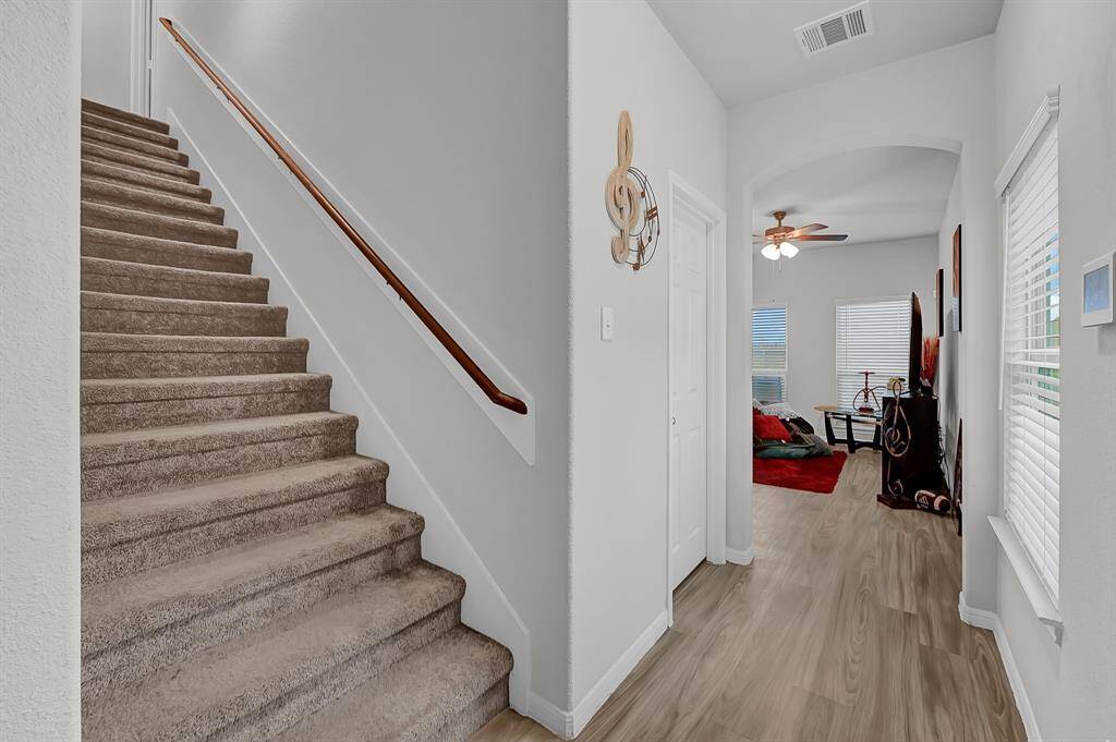Stairs leading upstairs to bedrooms upon entry.