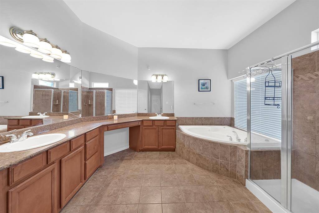 The primary bathroom offers vanity seating, soaking tub, and stand alone shower. (Not pictured separate toilet room.)