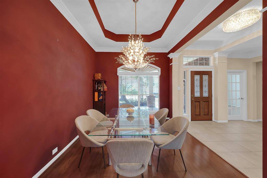 Formal dining room with trayed ceiling boasts a grand chandelier that adds a touch of elegance.