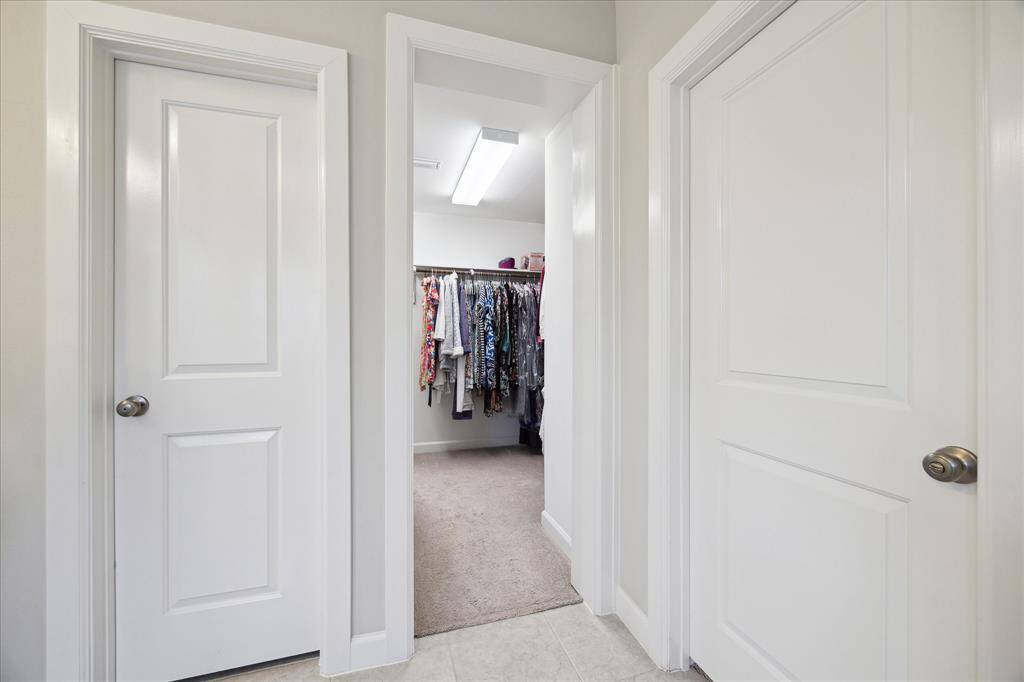 Entry to the primary walk-in closet with exceptional storage and hanging space.
