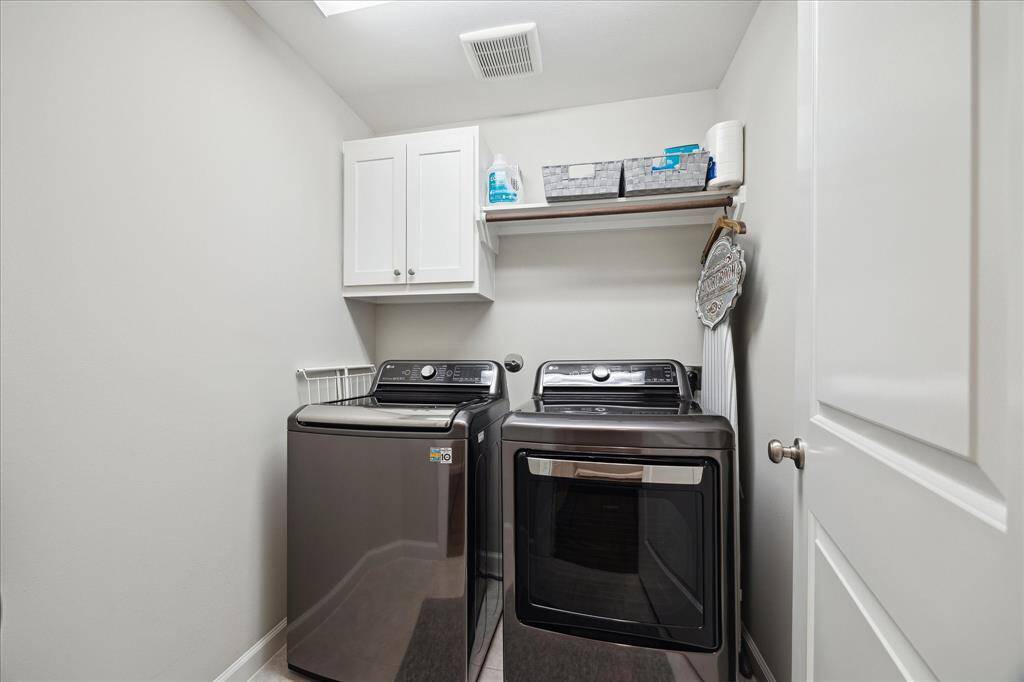 This is a compact, well-organized laundry room with shelving, handing space and storage.