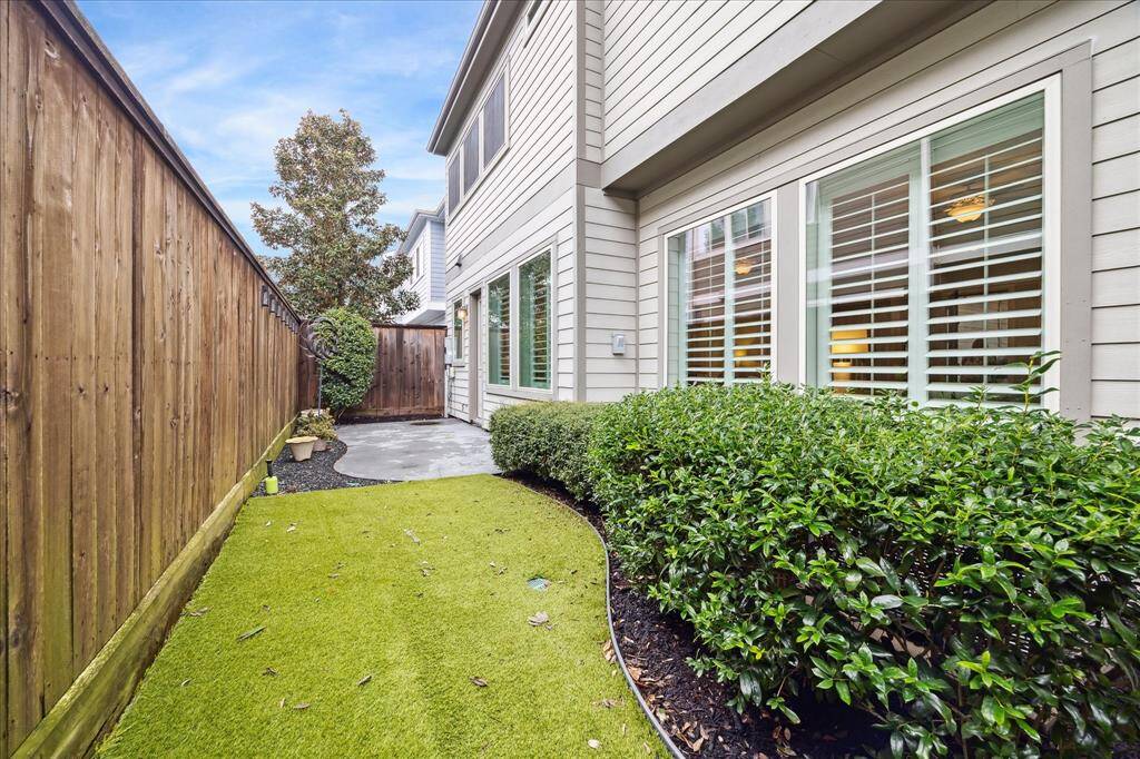 Current owner added beautiful landscaping and artificial grass, for a low maintenance outdoor living experience. Ample space for outdoor seating, grilling, firepit - exceptional outdoor entertaining space in addition to the front covered patio as well.  It's a cozy outdoor space for relaxation or light gardening.